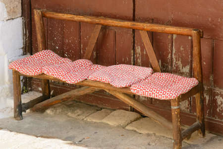 old wooden bench with cushions in paintingsの写真素材