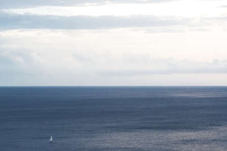 Sea and sky with sailboat in solitaryの写真素材