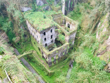 Aerial view of old castle buildings in mountains overgrown with grassの写真素材