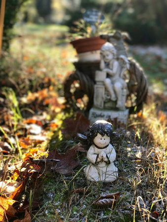 Little garden sculptures close-up on the ground with withered leavesの写真素材