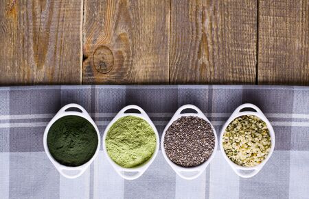 Superfood raw seeds and powder. Body building powders and health food on wooden background. Superfood served in small bowls.の写真素材