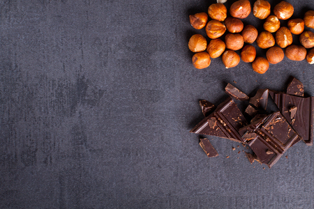 Bitter chocolate and hazelnuts on corner, black stone background.の写真素材