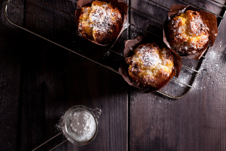 Muffins with white powdered sugar on wooden background.の写真素材