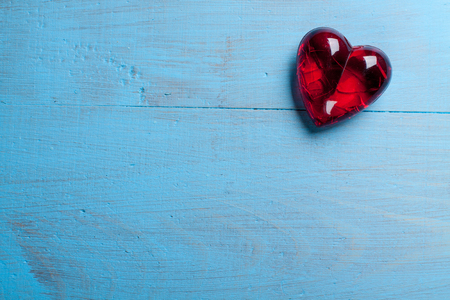 Red heart on blue wooden background. Symbol of love in valentine's day.の写真素材