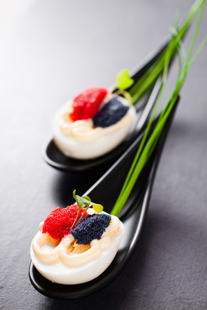 Appetizer on fingerspoon egg with caviarの写真素材