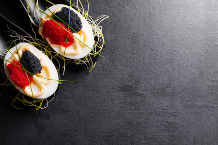 Appetizer on fingerspoon egg with caviar with copy space.の写真素材