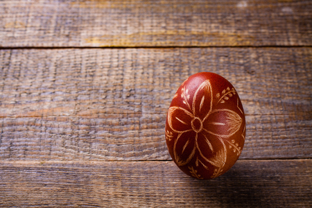 Scratched handmade Easter egg on wooden background.の写真素材