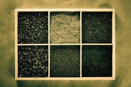 Mixed tea in a wooden box on jute background.