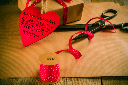 Valentines day gift wrapping with boxes and scissors over paper or wooden background.の写真素材