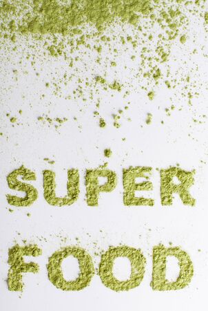Word piled of green superfood powder of barley grass on a white background.の写真素材