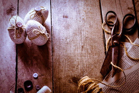 Easter eggs covered with scraps of newspaper wrapped in a jute twine with glued buttons. Handmade easter egg decoration.の写真素材
