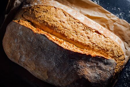 Fresh bread on roast paper in black stone background.の写真素材