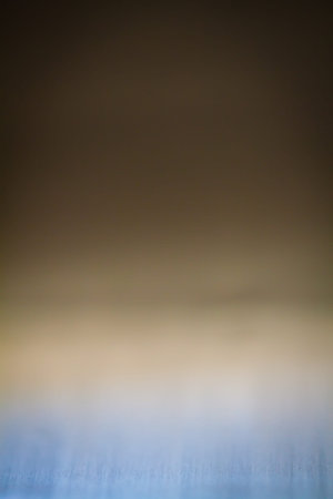 Abstract background with blurred gradient in blue, brown and yellow colors.