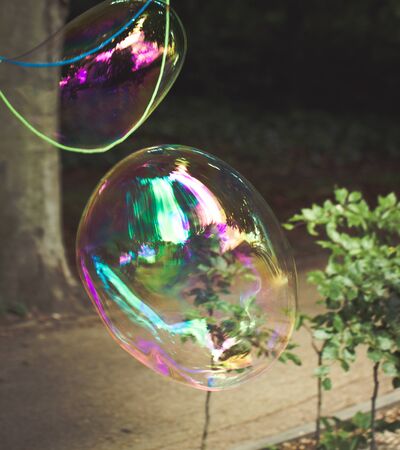 Big soap bubbles created with ropes and sticks in a park.の写真素材