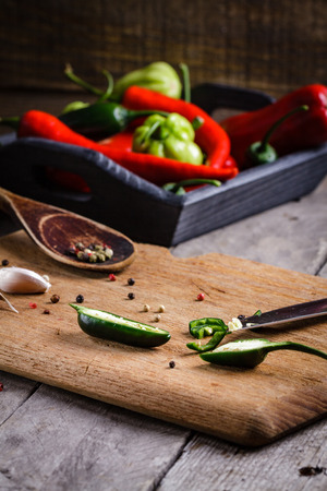 Colored pepper and garlic on cutting board.の写真素材