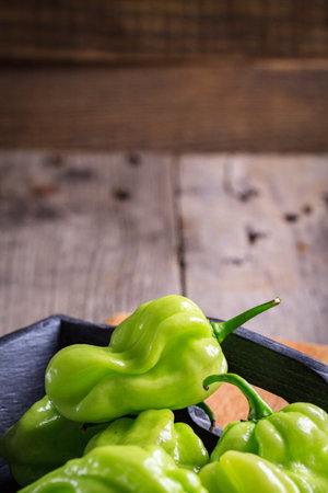 Green hot habanero peppers on cutting board.