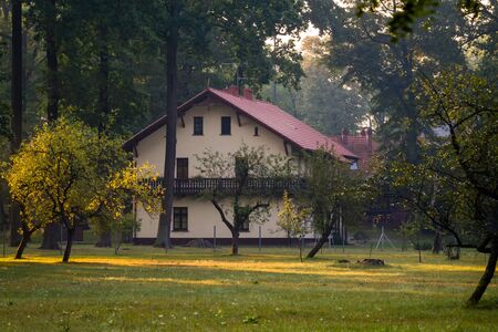 Foresters house building among surrounding trees of forest and orchard.の写真素材
