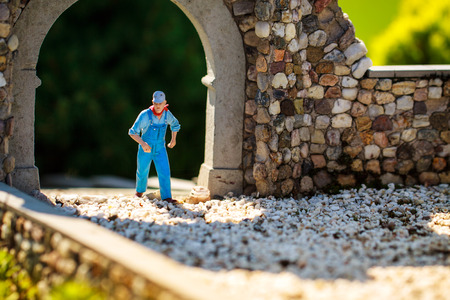 Gardener small figurine walking on stone gate.の写真素材