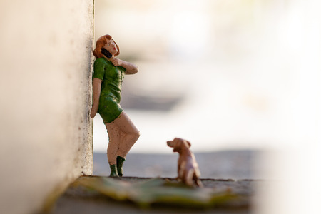 Small figurine woman talking with phone stand in the gate.の写真素材
