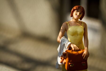 Small figurine of business woman look on briefcase.の写真素材