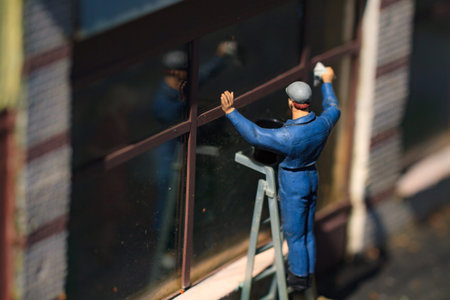 Small figurine of man clean the big window from a ladder.の写真素材
