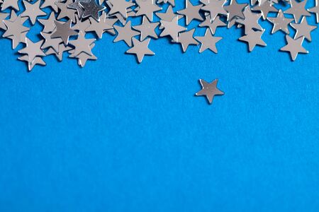 Frame of scatters little silver stars on blue background.の写真素材