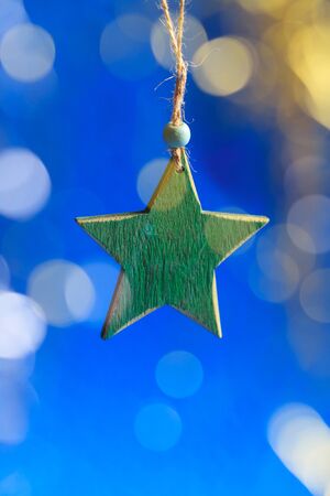 Greeting card with wooden green star and blurred glitter glow.の写真素材