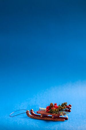 Christmas card in vertical orientation with decorative sledge standing on blue background.の写真素材