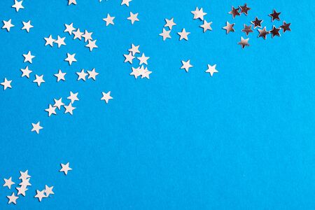 Frame of scatters little silver stars on blue background.の写真素材