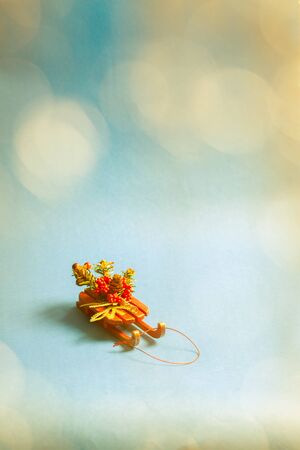 Christmas card with decorative sled standing on blue background in blurred glow balls.の写真素材