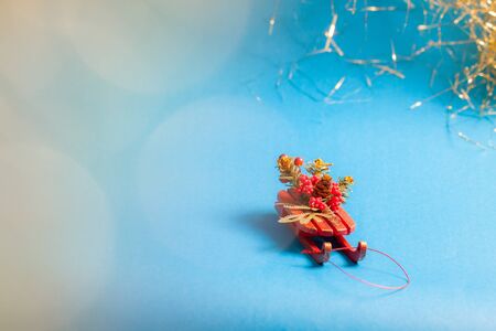 Christmas card with decorative sled standing on blue background in blurred glow balls.の写真素材