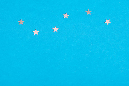 Frame of scatters little silver stars on blue background.