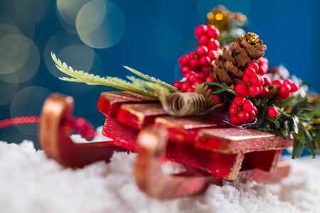 Decorative sleigh with roan-tree and Christmas tree branches, driving on snow, in the background the beautiful bokech balls.の写真素材