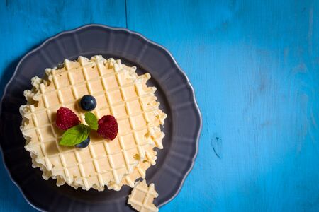 Belgian waffles with fresh blueberry and raspberry, decorated mint leaves.の写真素材