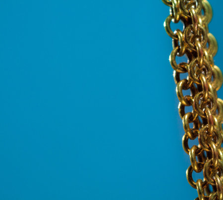 Gold chain on blue background right side of the photo.