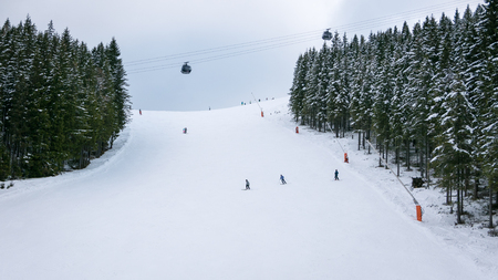 Skiers and snowboarders riding on a ski slope in Jasna Chopok in Slovakia ski resort.の写真素材
