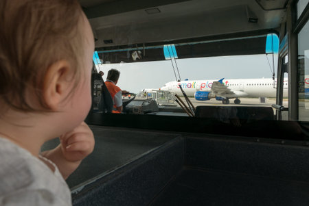 Kos island, Greece - 13 May 2017: Baby look at the plane from bus cabine,  she's very fascinated by the view.のeditorial素材