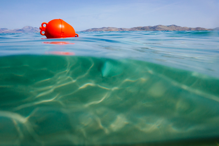 Marker buoy on surface of water. View half and half underwater.の写真素材