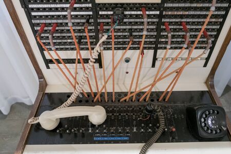 Old telephone exchange with lines and earphone.の写真素材