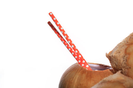 Coconuts with open one of them and orange straws to drink fresh water. Nature cocos background.の写真素材