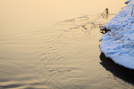 Sunlight reflection and wrinkles on stream in winter aura.の写真素材