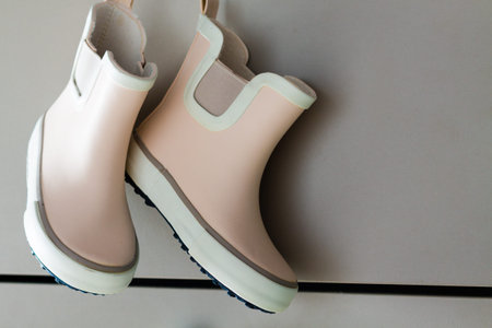 Pink little children rubber boots, concept of autumn or spring background.