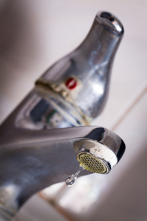 Old leaking faucet with stone and calcium sediments due to hard water.の写真素材
