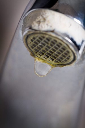 Old leaking faucet with stone and calcium sediments due to hard water.の写真素材
