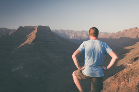 Young man is staying above the canyon on Gran Canaria Mountains. Climatic retro photography. の写真素材