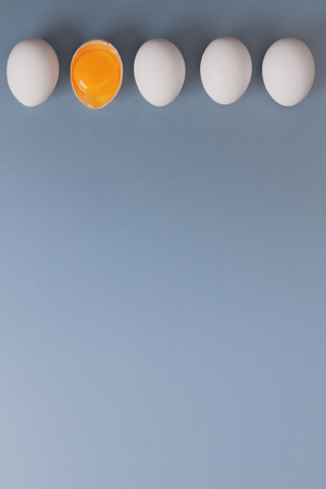 White eggs is laying in row, one of them is bisected and shows yolk. の写真素材