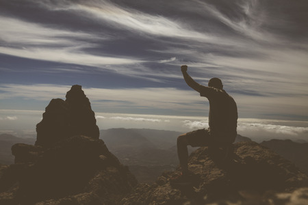 Silhouette man raising up hands on mountain on Gran Canaria island.の写真素材