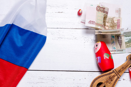 Russian symbols matryoshka, balalaika, rubles cash and flag of russian federation on wooden background.の写真素材