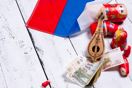 Russian symbols matryoshka, balalaika, rubles cash and flag of russian federation on wooden background.の写真素材