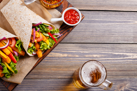 Tortilla with chicken and vegetables and beer to drink.の写真素材